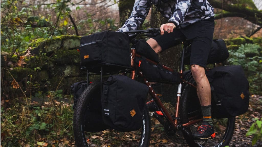 Man on bike loaded with Restrap Expedition series bags