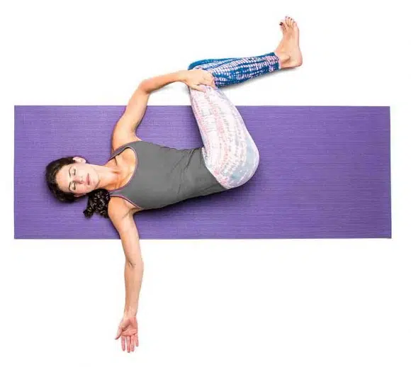 Woman Performing Supine Spinal Twist Stretch