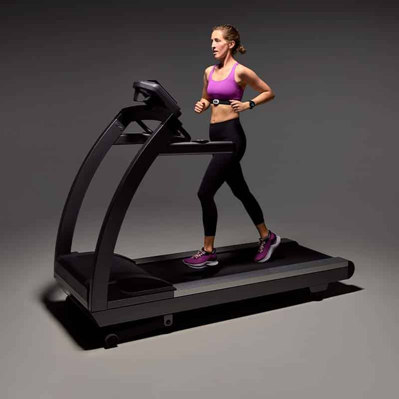 Woman running on a treadmill wearing a GARMIN HRM-PRO PLUS
