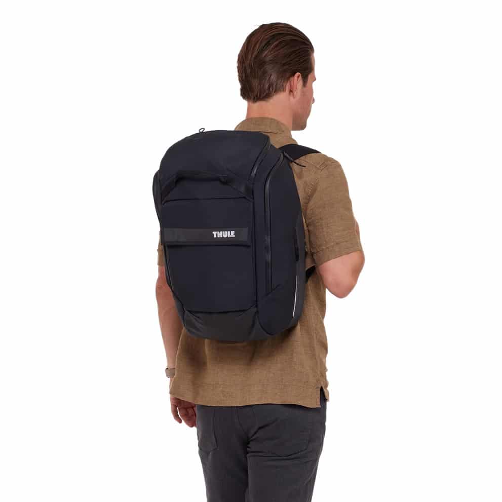 Thule Paramount Hybrid Pannier Backpack over man's shoulder