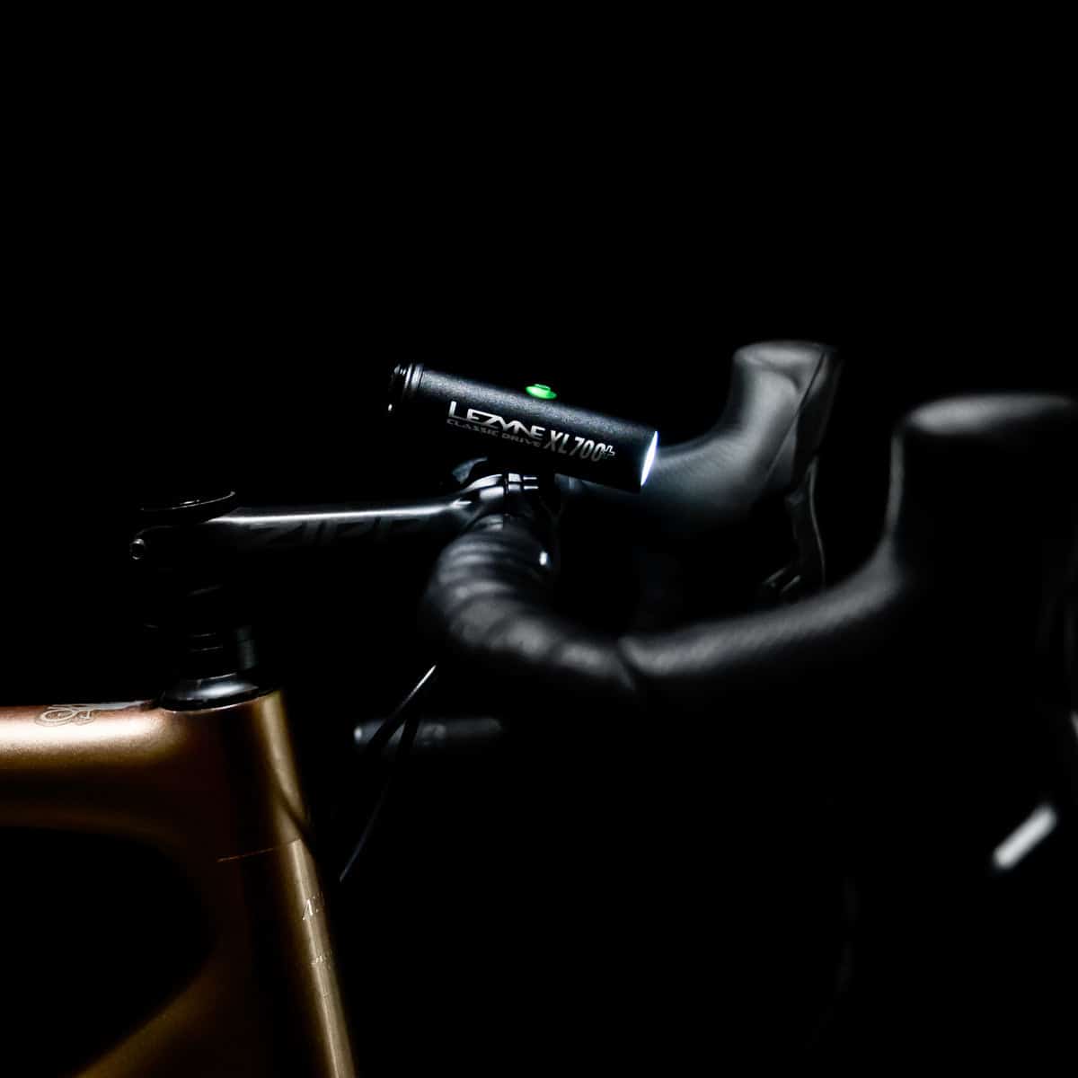 LEZYNE Classic Drive XL 700+ Light side shot attached to handlebar with light on and logo visible