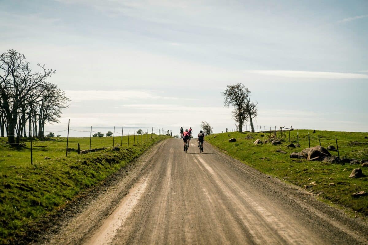 Cyclists riding up a gravel road