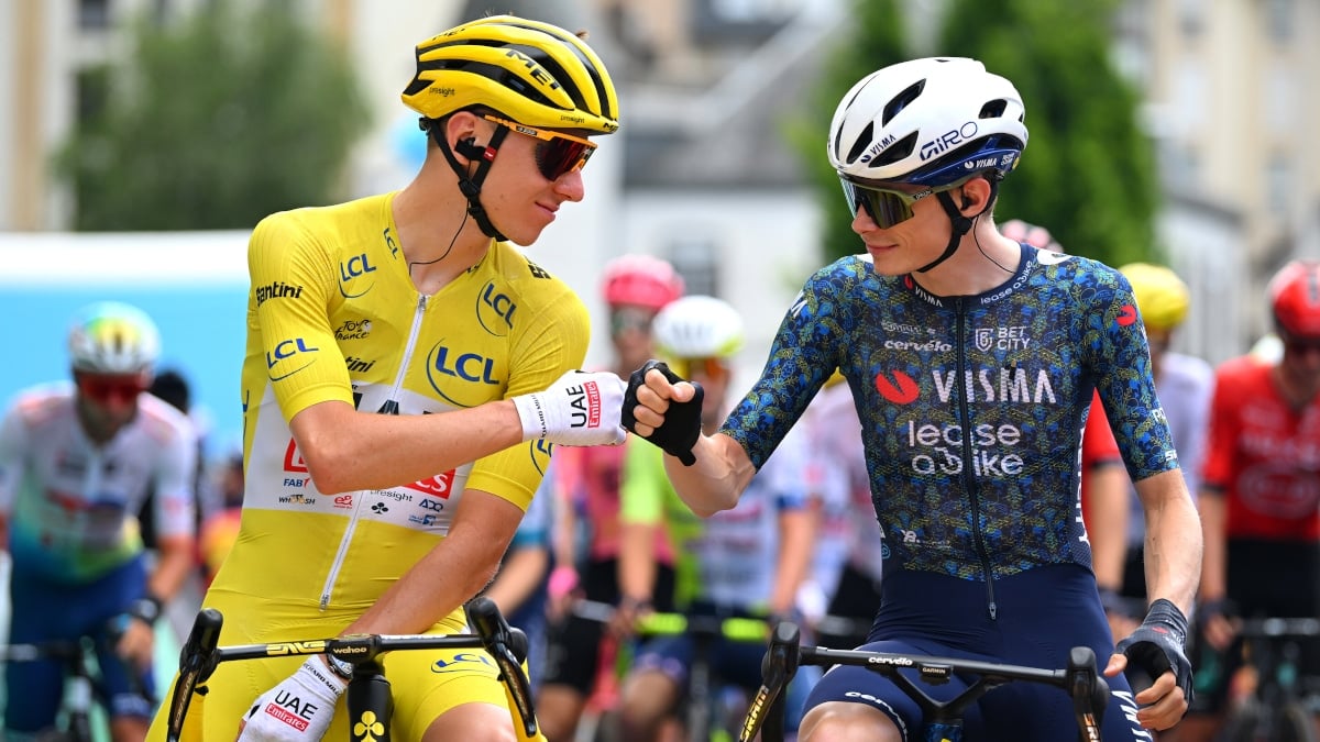 tadej pogacar and jonas vingegaard fist bumping before a stage at the tour de france