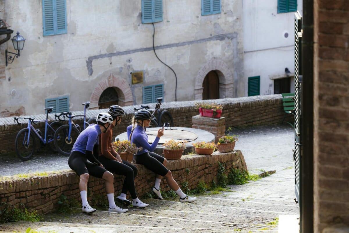 Cyclists sitting having a rest with bikes leaned against a wall in Europe
