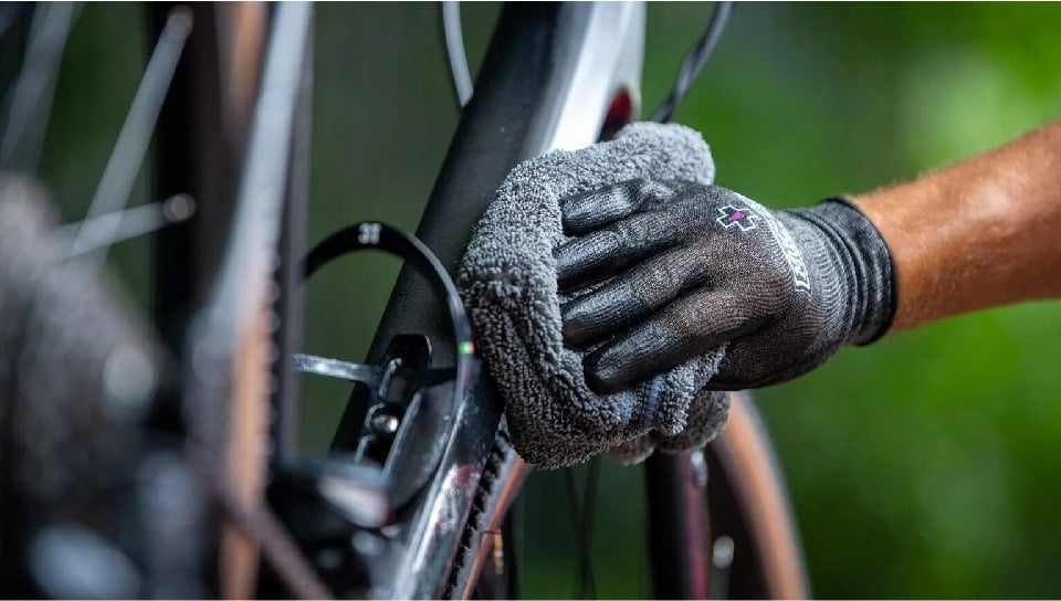 Bike Maintenance 101: Mechanic wiping down bike frame